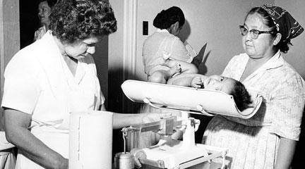 Photo, "Baby being weighed by nurse," IHS, 1887-1969, Dept. of Health