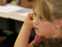 An elementary student listening to her teaching during class. NHEC