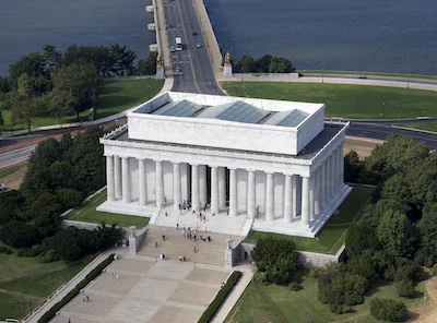 Aerial view of the Lincoln memorial. White rectangular granite building with stairs leading up to it and columns around the sides.