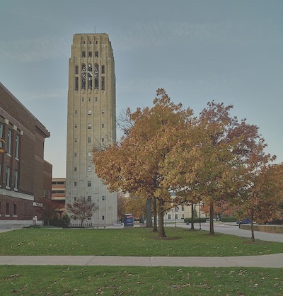 Tall stand alone tower with a number of small windows looking out and a clock at the top