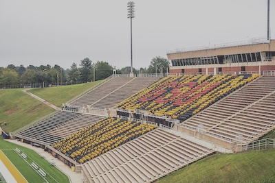 One side of an outdoor stadium seating section. The rows of seats spell out GSU in red lettering