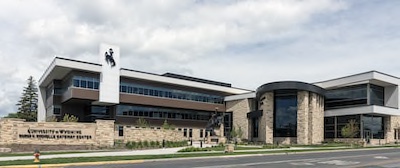 Large building with large windows and a cowboy statue of a person riding a bucking horse.