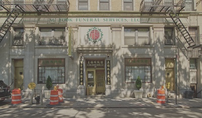 Front of building reading NG Fook Funeral Services. Construction equipment surrounds the building.