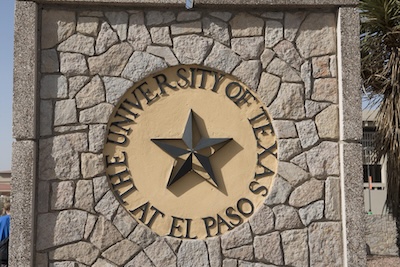 Outside, stone sign with a circle in the center reading The University of Texas at El Paso. Those words encircle a star. 