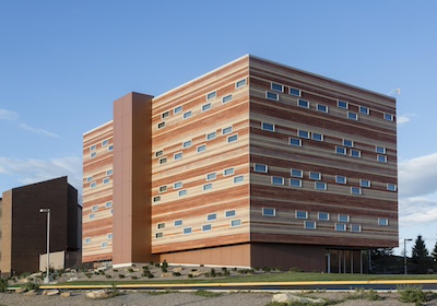 Large cube shaped building with red-orange and tan stripes made to look like layers.