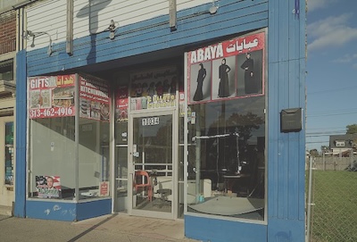 A small store advertises Abaya and Gifts in English and Arabic.