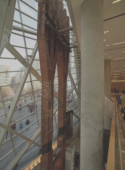 View from inside the World Trade Center Memorial and Museum in New York City. Two rusted steel beams several stories tall stand by the window.