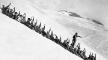 Photo, Party 'nature sliding' on the perpetual snow slopes below Paradise Glacier. These parties are under guide direction. Individuals are equipped with the famous 'tin trousers.' The seats of these trousers are paraffined. Parties are seated together on the snow and slide long distances, By Jacobs, Mount Rainier National Park, Washington, ca. 1917 National Archives and Records Administration Photo, Party 'nature sliding' on the perpetual snow slopes, NARA