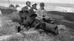Photo, Four black boys sitting on a cannon by a waterfront, W Jackson, 1902, LoC