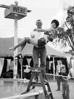 Photo, A man standing on a ladder holds a..., Cuyahoga County Fair, 1964